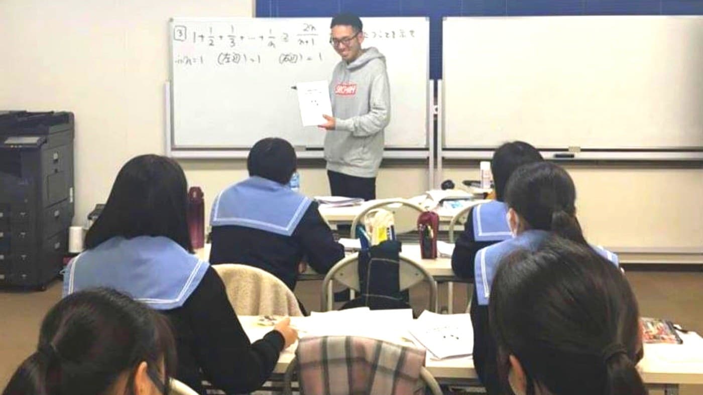 グループ授業で生徒に数学を指導するながめ先生